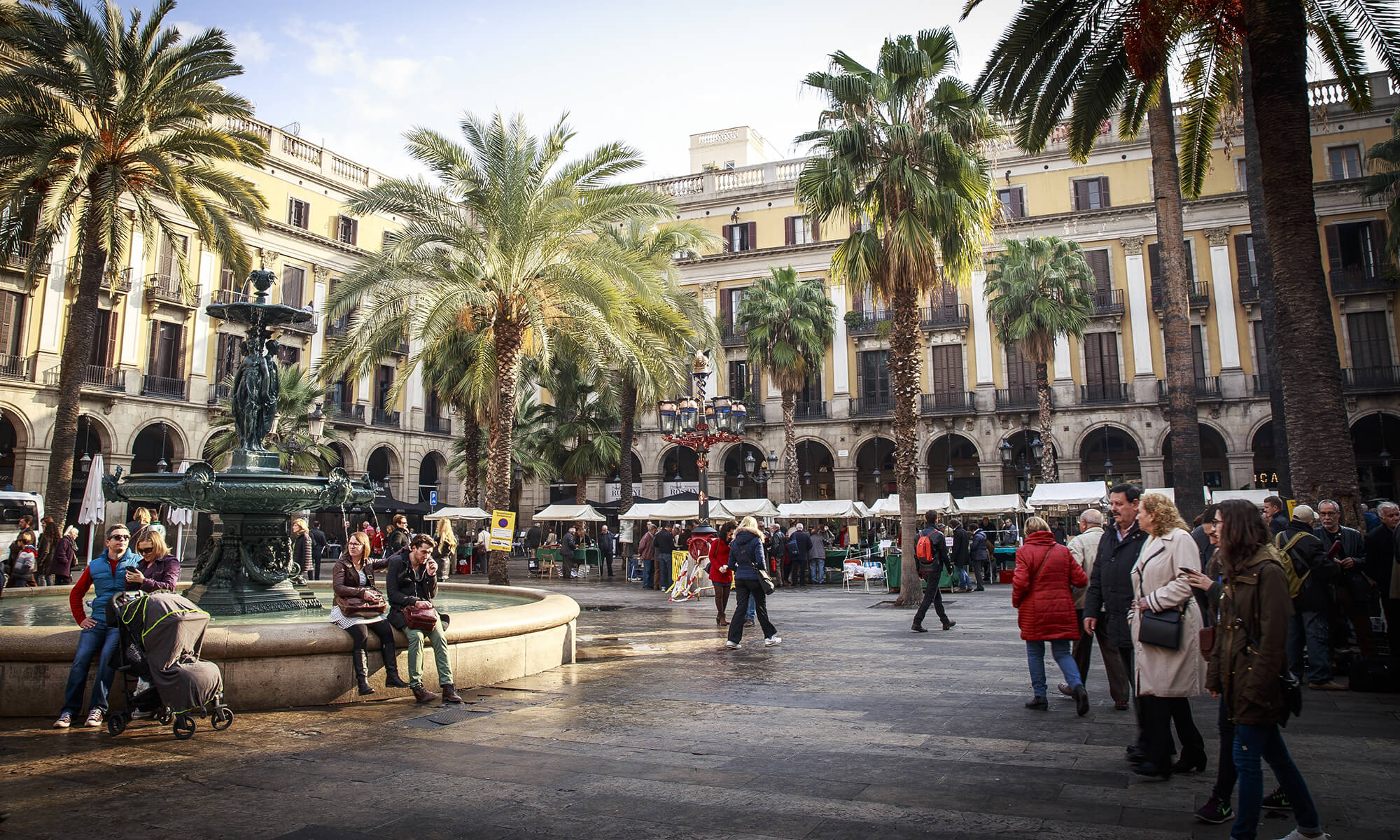 Plein in Barcelona met palmbomen en mensen die genieten van het Spaanse leven