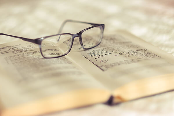 Libro abierto con gafas para aprender las reglas del acento en español